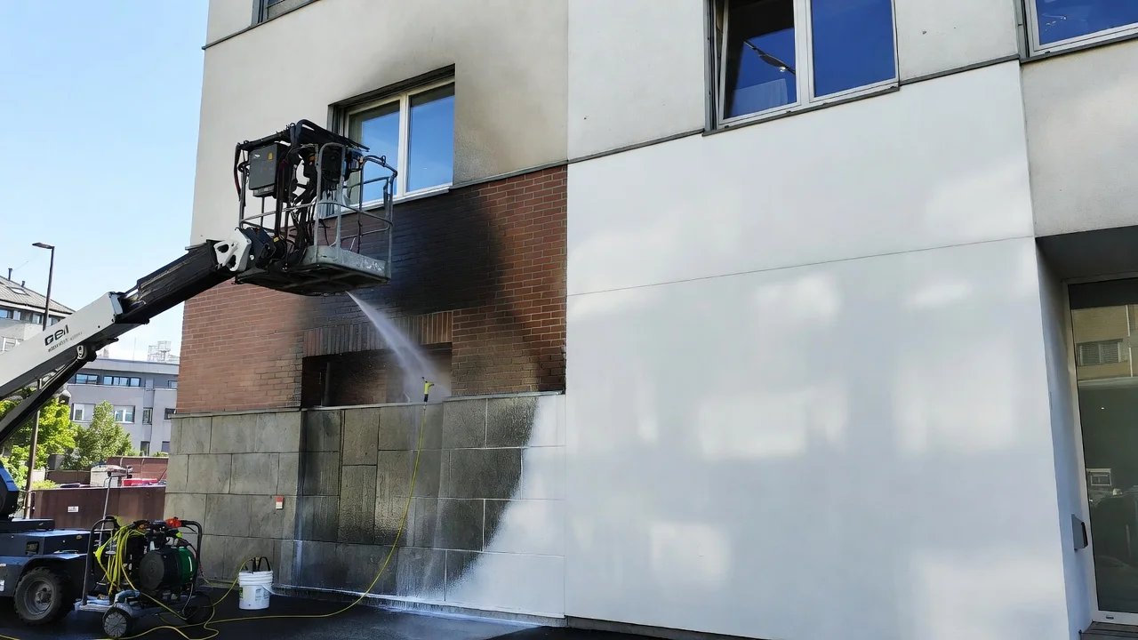 Fassadenreinigung vs Neuanstrich in Zürich Vergleich einer sauberen Gebäudefassade nach professioneller Reinigung mit frisch gestrichener Seite.